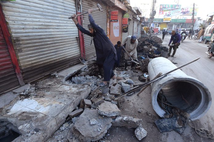 Labourer working on construction work of a sewerage nallah at Tench Bhatta