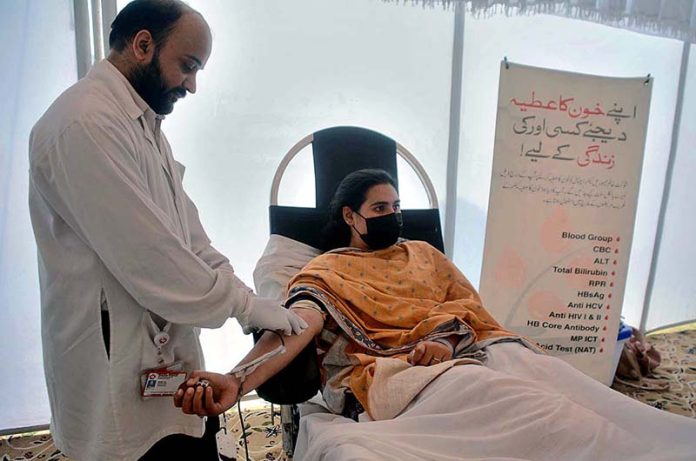 Student donating blood during Voluntary Blood Donation Camp organized by Shaukat Khanam Hospital at SBBWU