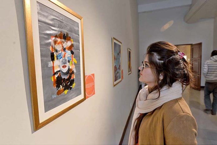 A girl viewing a painting at the art exhibition on 