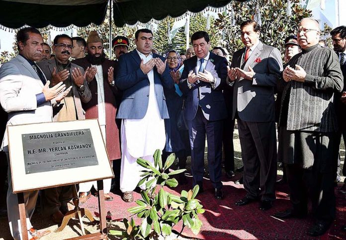 Chairman Mazhilis of the Parliament of Kazakhstan Yerlan Koshanov and Speaker National Assembly Raja Pervez Ashraf offering prayer after planting a Magnolia Grandiflora sapling at Parliament Lawn