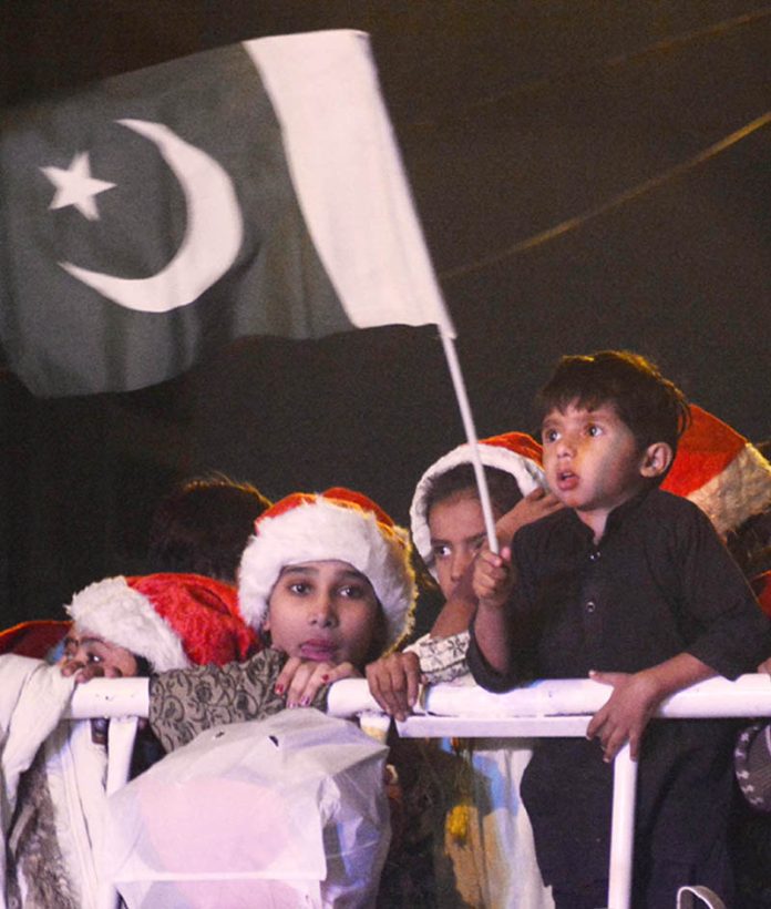 A child waving Pakistani flag in Pakistan Christmas Peace Rally