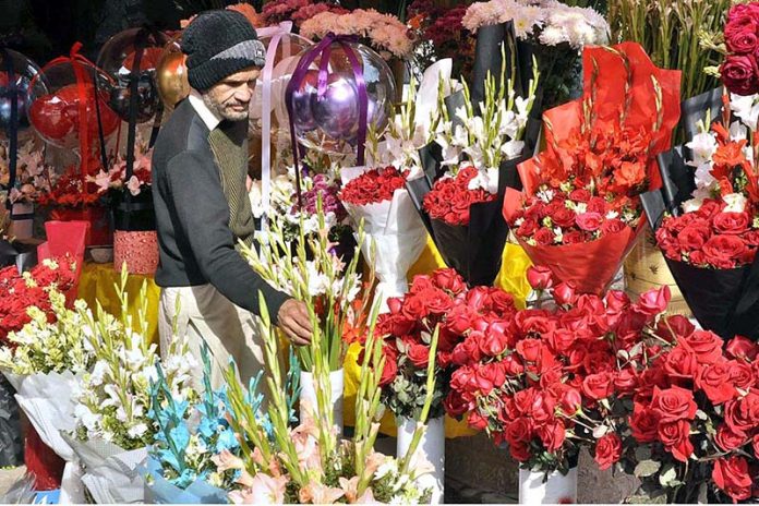 A vendor displaying flower bouquets to attract customers at F-7Flower Market