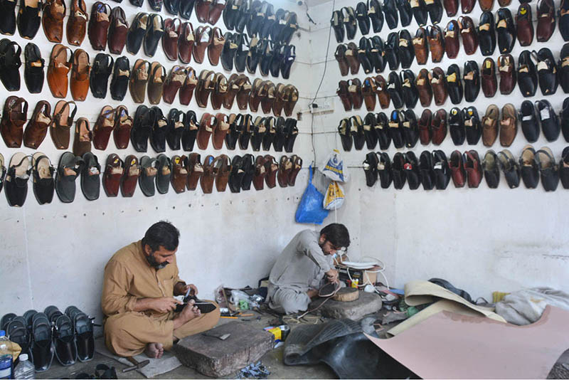 Shoemakers preparing traditional footwear (Peshawari Chappal) at their ...