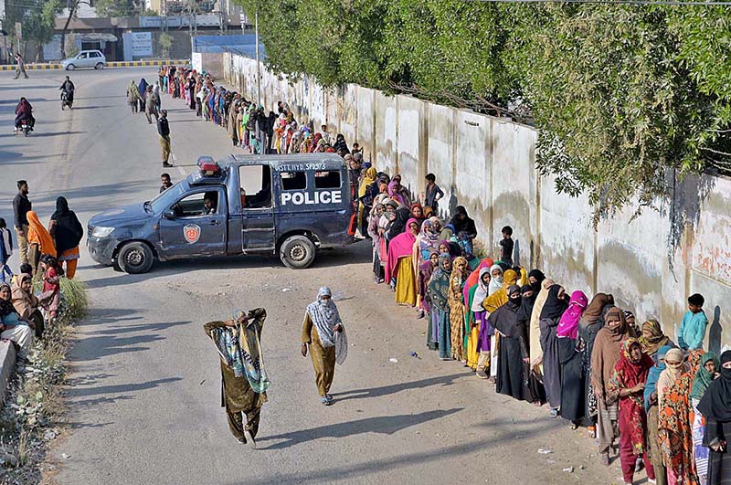 Women going back home after purchased subsidized flour from a delivery truck near Niaz Stadium