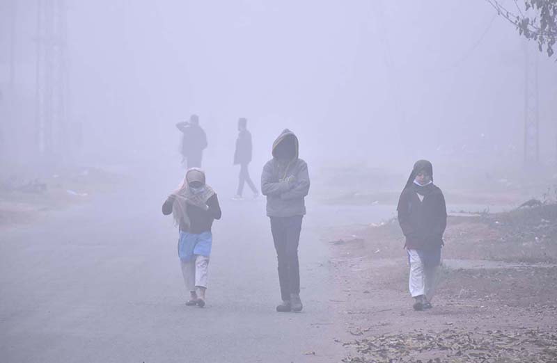 Students are going to their school during dense fog during extreme