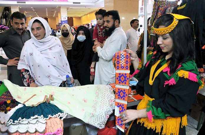 People visiting different cultural stalls during exhibition titled 