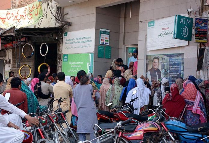 A large number of deserving women standing outside Habib bank (HBL) to draw the Banazir income support Program cash at Satyanal Road