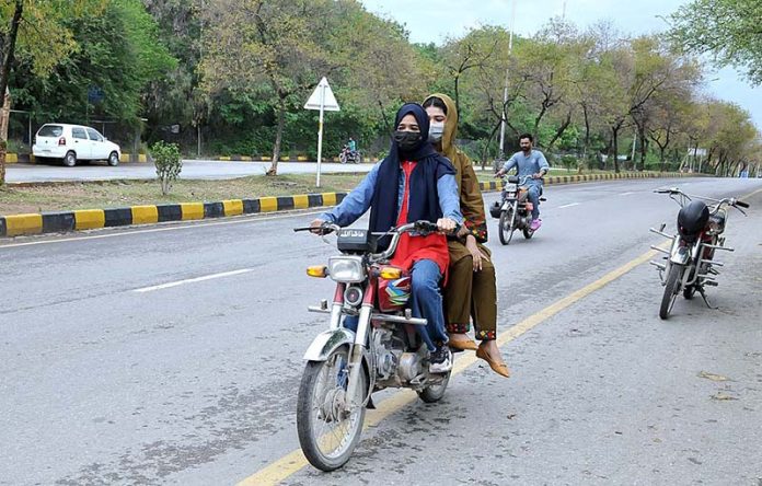 Women riding on a motorbike towards their destination in the Federal Capital.