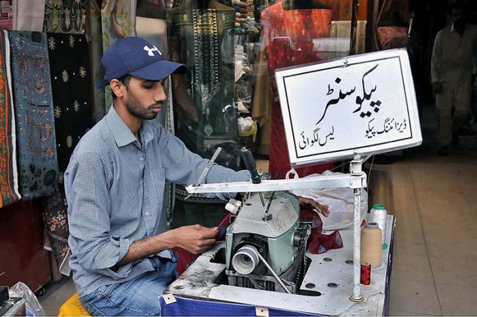 Tailor busy in pico on dupatta for upcoming Eid ul Fitr festival at Aabpara market.