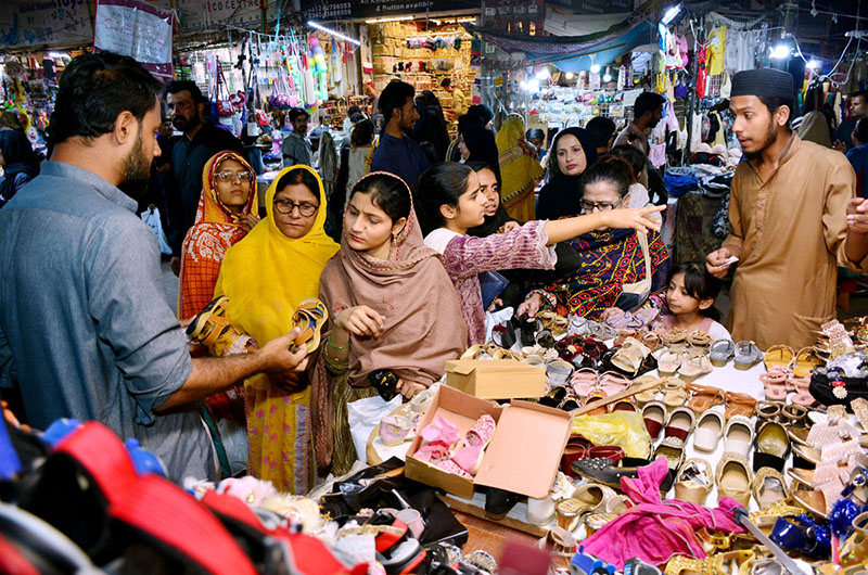 Woman with her girls purchasing jewelry during Eid shopping in preparation of upcoming Eid-ul-Fitar at cloth market Latifabad