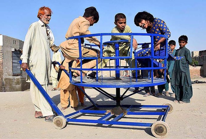 Children enjoying a swing at marry-go-round outside their houses at Rice Canal Road