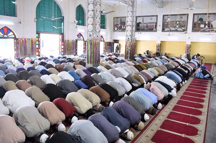 A large number of people offering Namaz-e-Jumma at a mosque during holy ...