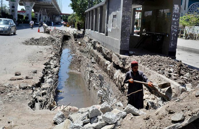 Labor busy in construction work of sewage line near Shamsabad at Murree Road