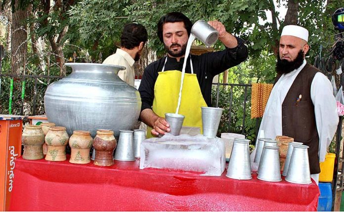 A roadside vendor prepares traditional drink to attract customers at Zarghoon road