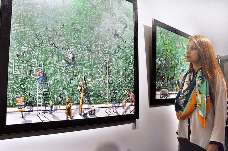 A visitor viewing the painting during Painting and Sculptures Exhibition (Conceptual Reality “Bridging Thoughts on Canvas”) at Revivers Galleria