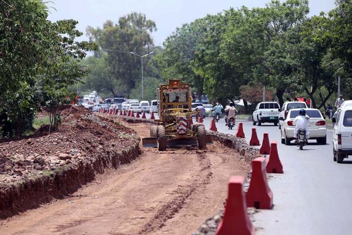 Heavy machinery being used to a expand a road at Chak Shahzad neighbourhood in the Federal Capital