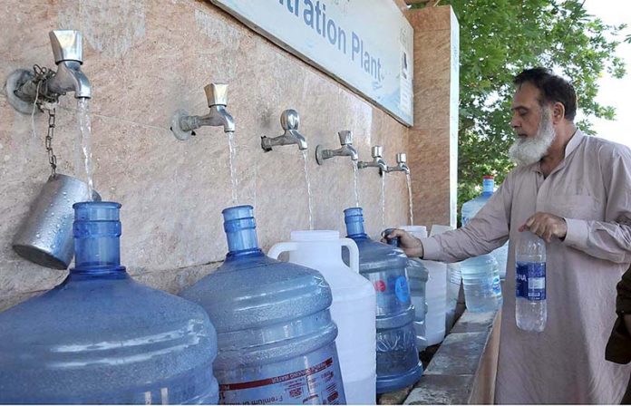 Man filling water bottles from Water Filtering Plant at H-8