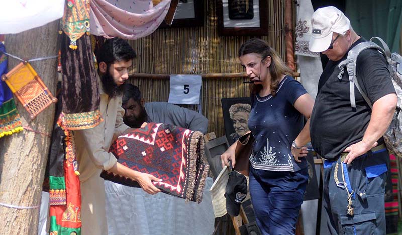 Artist plays his musical instrument flute to attract people during Saqafati Mela at Lok Virsa