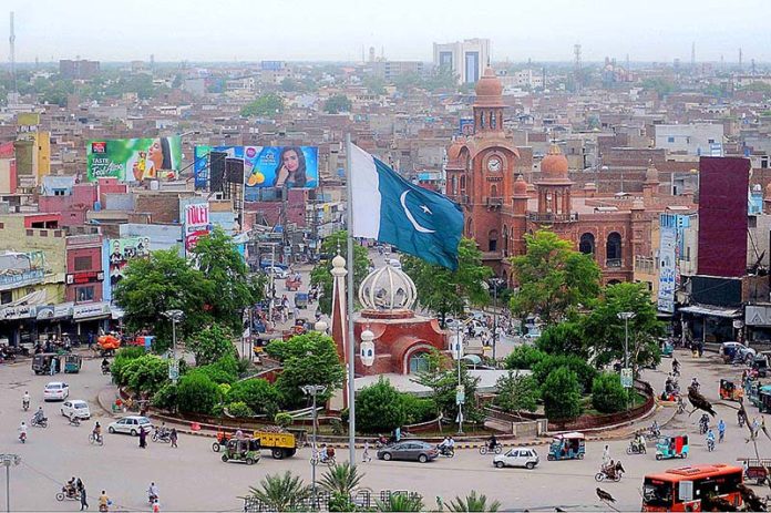 A View Of The Clock Tower Chowk, With Its Bustling Traffic And Vibrant 