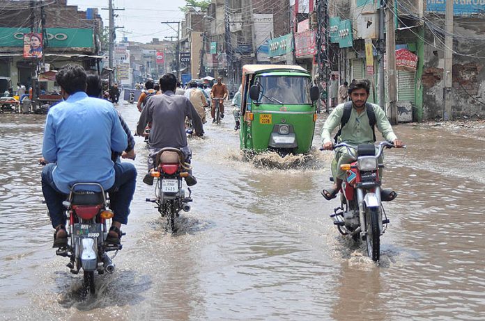 Commuters faces a challenging task of crossing stagnant water amidst ...