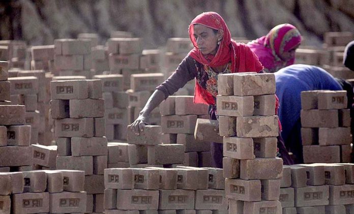 A labourer arranging raw bricks at a local brick kiln