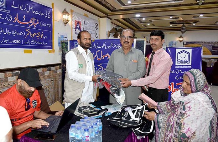 Volunteers of Al-Khidmat Foundation are distributing travel bags among pilgrims at Hajj camp of Ministry of Hajj