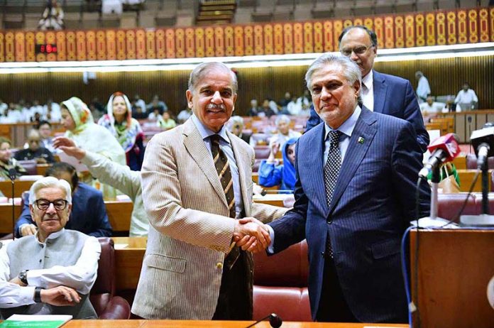 Prime Minister Muhammad Shehbaz Sharif shaking hands with Federal Minister for Finance Muhammad Ishaq Dar after the budget speech 2023-24 in the National Assembly