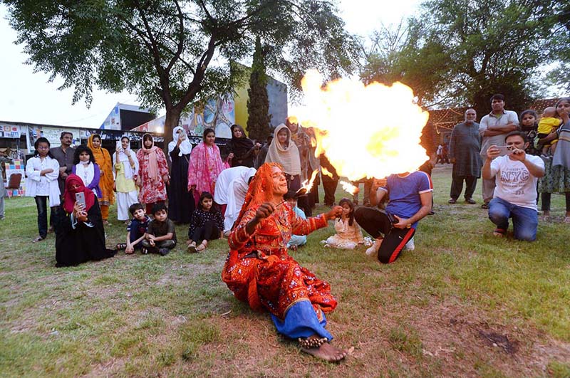 A folk artist from Cholistan blowing fire from mouth during Saqafati Mela at Lok Virsa