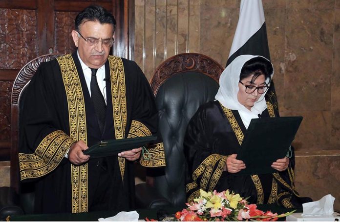 Honorable Chief Justice Mr. Justice Umar Ata Bandial left is administering the oath to Justice Supreme Court judge of the Hon ble Ms. Justice Musarrat Hilali Chief Justice Peshawar High Court as Judge