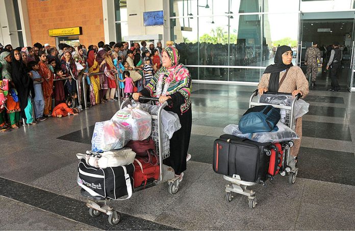 Pilgrims coming out from the airport as First Hajj flight landed after performing Hajj at Multan International Airport