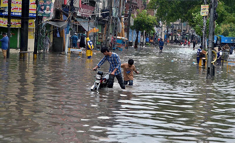 Children wading through water accumulated in Lakshmi Chowk due to heavy rain