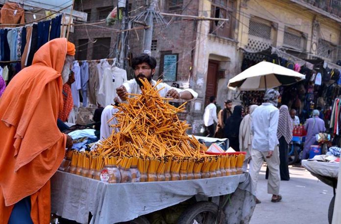 A vendor displaying the stationary items pencils to attract the customers outside the Data gunj Buksh Road