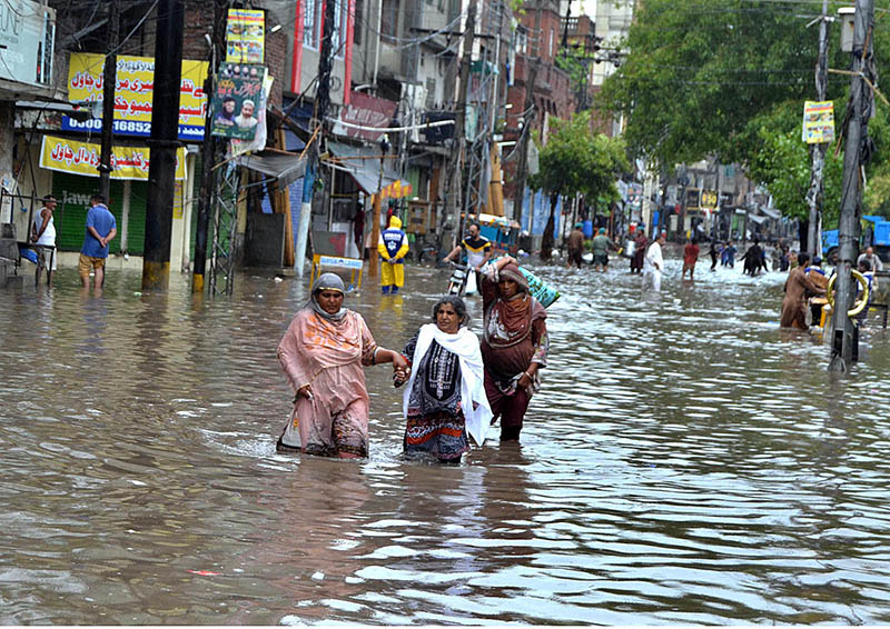 Children wading through water accumulated in Lakshmi Chowk due to heavy rain