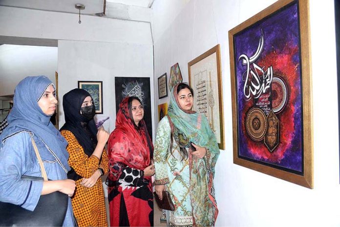 Women viewing art and calligraphy exhibition at Al-Hamra Hall