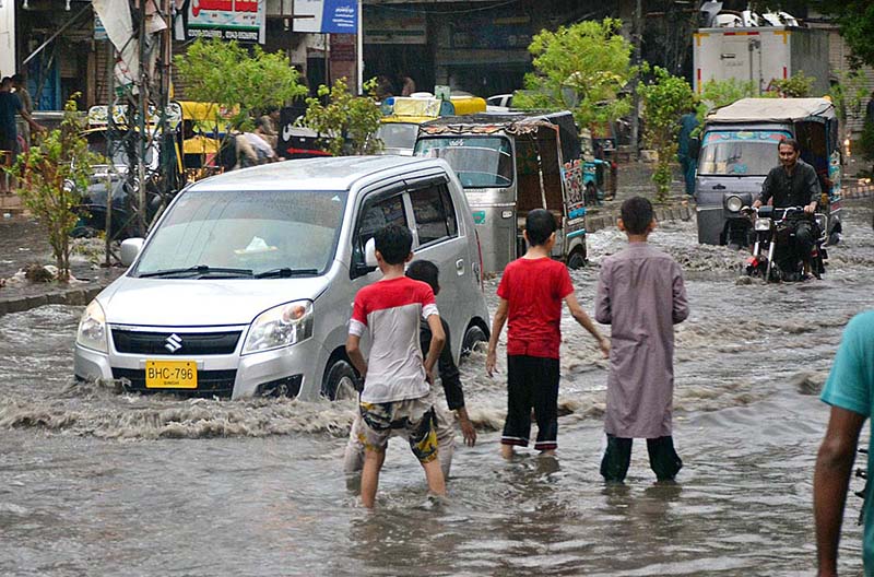 Vehicles passing through accumulated water after heavy rain in the city