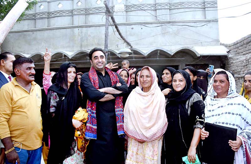 Chairman PPP and Foreign Minister Bilawal Bhutto Zardari giving away house ownership right document to flood victims under the Sindh People's Housing Scheme during a visit to a house built for them at village of Vikia Sangi