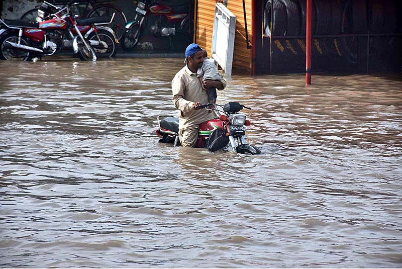 Vehicles passing through rain water accumulated on the road near Kalma Chowk during rain that experienced in the city