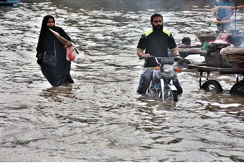 Vehicles passing through rain water accumulated on the road near Kalma Chowk during rain that experienced in the city