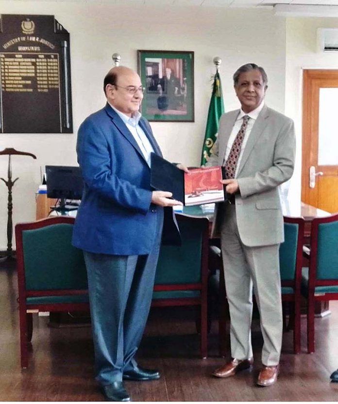 Federal Insurance Ombudsman (FIO) Dr. Muhammad Khawar Jameel is presenting the Annual Report 2022 of FIO to Minister for Law and Justice Senator Azam Nazir Tarar