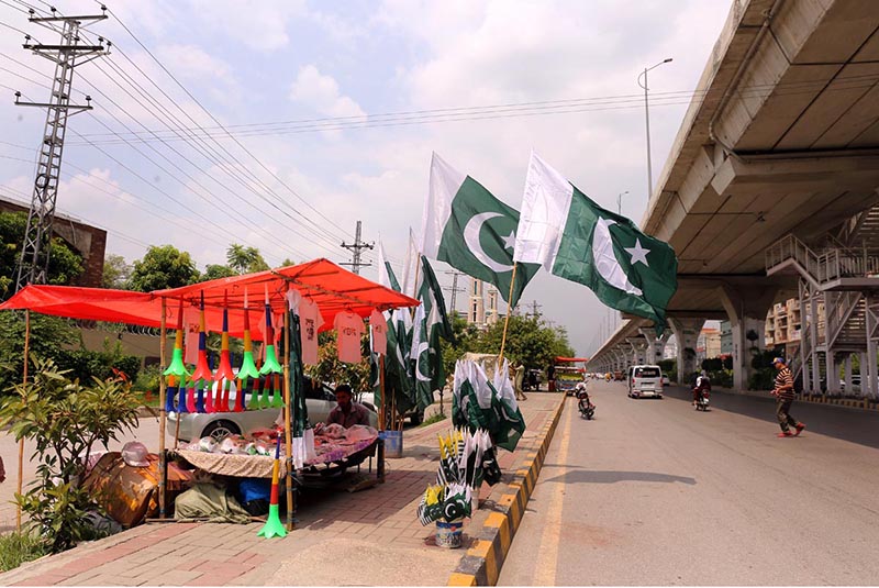 A vendor displaying and selling 14th August related stuff to attract customers at his roadside setup in the city