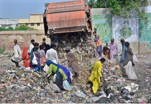 Gypsy people searching valuables items in the garbage at Latifabad