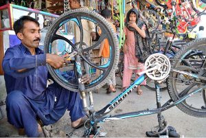 A mechanic busy in repairing a cycle at Liaqat Market