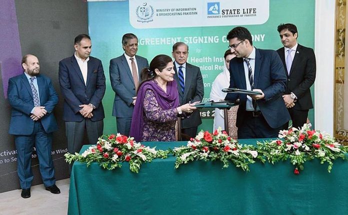 Director General, Directorate of Electronic Media Publications Ms. Samina Farzin and Divisional Head of State Life Insurance Corporation Mr. Muhammad Ashar signing MoU for provision of health insurance to artists and technicians associated with Pakistan's film industry. Prime Minister Shehbaz Sharif and Information Minister Ms Marriyum Aurangzeb witnessing the ceremony