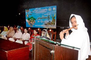 Student plays national song on flute during a ceremony on the occasion of Defence Day of Pakistan at Women University Multan.