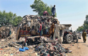 Labourer loading valuables on tractor trolley after collecting from garbage at Tando Yosuf Road. 