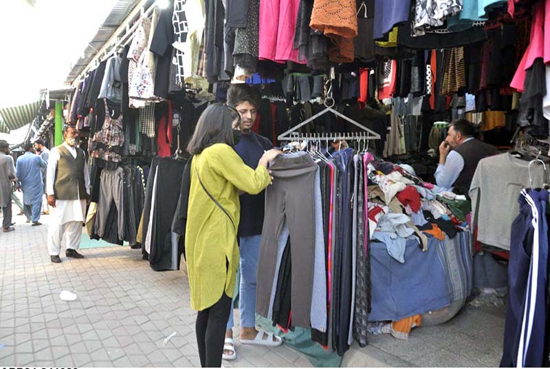 People purchasing clothes from a vendor at H9 Bazar in the Federal Capital