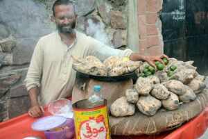 A vendor selling food item Shakar Khandi at his road side setup. 