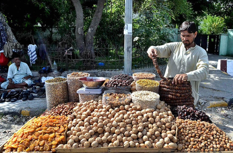 A vendor arranging and displaying the different kinds of Dry fruits to ...