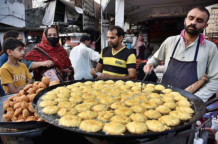 A vendor is busy in making and selling the traditional food item “Laddu ...