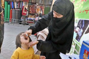 Health worker marking the finger of child after administering polio drops during anti polio campaign at Weekly Bazaar in Federal Capital.